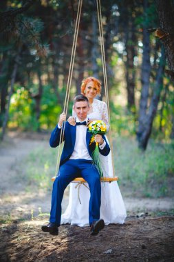 Mavi takım elbiseli, beyaz elbiseli ve buketli güzel bir çift.