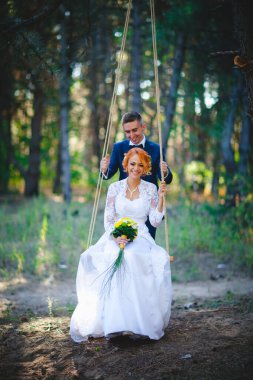 Mavi takım elbiseli, beyaz elbiseli ve buketli güzel bir çift.