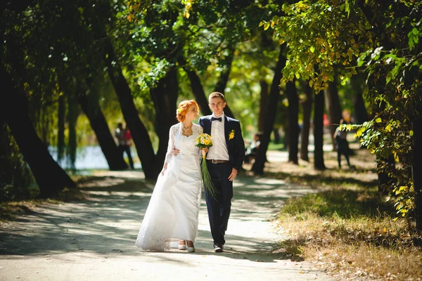 ブルーのスーツを着た若い美しいカップルと花束付きの白いウェディングドレス — ストック写真