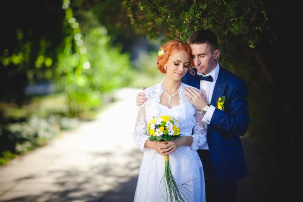 Mavi takım elbiseli, beyaz elbiseli ve buketli güzel bir çift.