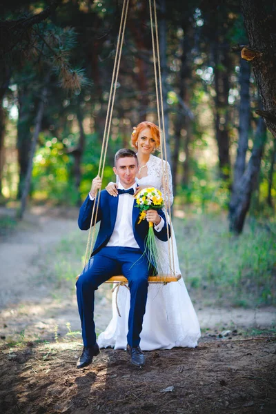 Mavi takım elbiseli, beyaz elbiseli ve buketli güzel bir çift.