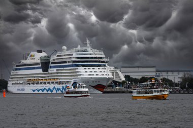 Warnemuende, Almanya 30 Temmuz 2012 Seyahat gemisi Aidablu ile birlikte bulutlu bir gökyüzü ile Warnemuende limanında keşif botları