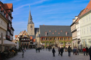 Quedlinburg, Almanya - 7 Ekim 2019 Quedlinburg pazar meydanının güneşli bir gününde arka planda kilise