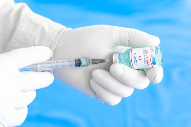 Revirdeki hastaya şırınga enjekte etmek için elinde şırınga tutan doktoru kapatın. Covid-19 ya da koronavirüs aşısı. Virüs temizleme ve önleme kavramı.