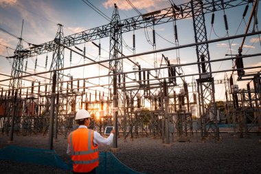 Mühendisler sistemin işleyişini dizüstü bilgisayarla kontrol ediyorlar. Elektrik dağıtım sistemindeki hatalar için her hafta güç dağıtım istasyonunun sistemini kontrol ediyorlar..