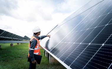 Güneş çiftliği (güneş paneli) mühendisleriyle birlikte sistemin işleyişini kontrol eder, dünyanın enerjisini korumak için alternatif enerji, temiz enerji üretimi için fotovoltaik modül fikri.