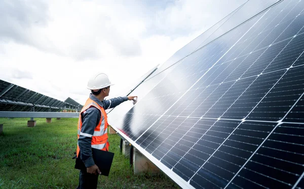 Güneş çiftliği (güneş paneli) mühendisleriyle birlikte sistemin işleyişini kontrol eder, dünyanın enerjisini korumak için alternatif enerji, temiz enerji üretimi için fotovoltaik modül fikri.