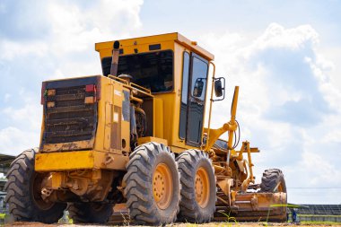 The ground grader is adjusting the road surface evenly to the level that engineers have calculated, industrial road construction, using state-of-the-art machinery to work for speed and accuracy.