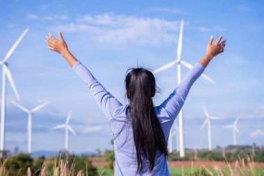 Wind turbines are an alternative electricity source to be sustainable resources in the future. People in the community with wind generators turbines. Clean energy concept saves the world.