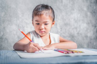A girl learning to paint on a book She is passionate and fun in learning about art, concepts for learning about colors, and training the hand muscles.