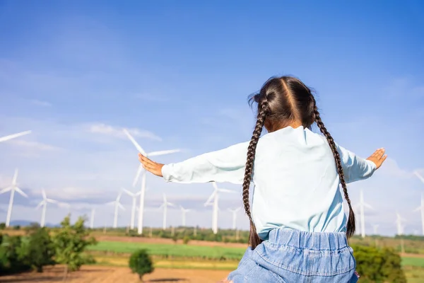 Wind turbines are an alternative electricity source to be sustainable resources in the future. People in the community with wind generators turbines. Clean energy concept saves the world.