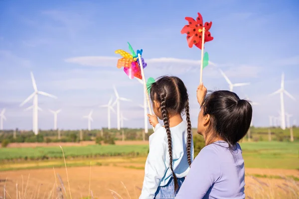 Wind turbines are an alternative electricity source to be sustainable resources in the future. People in the community with wind generators turbines. Clean energy concept saves the world.