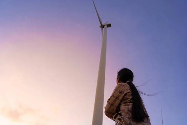 Wind turbines are an alternative electricity source to be sustainable resources in the future. People in the community with wind generators turbines. Clean energy concept saves the world.