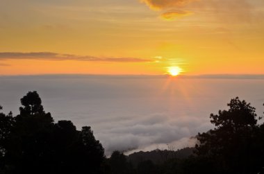 Bulutların üstünde renkli gündoğumu