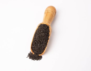 Tahta kaşıklı fesleğen tohumları beyaz arka planda izole edilmiş.