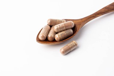 Tahta kaşık üzerinde üzüm özü tozu kapsülü