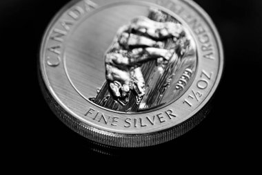 Macro Siyah ayna arkaplanındaki gümüş külçe sikkeyi kapat