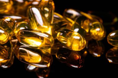 Omega 3 jel kapsülünü yansıtıcı siyah arka planda kapat