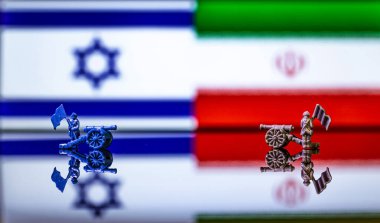 İsrail ve İran arasındaki savaşın kavramsal görüntüsü oyuncak askerler ve yansıtıcı bir arka plan üzerinde ulusal bayraklar kullanılıyor