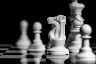 Yansıtıcı ayna yüzeyindeki siyah arkaplanı olan satranç taşlarını kapat