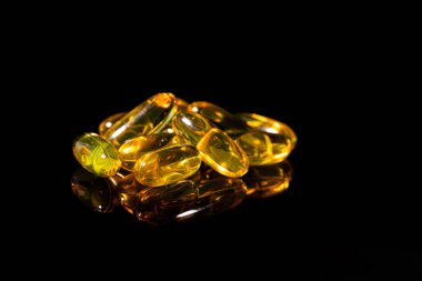 Omega 3 jel kapsülünü yansıtıcı siyah arka planda kapat