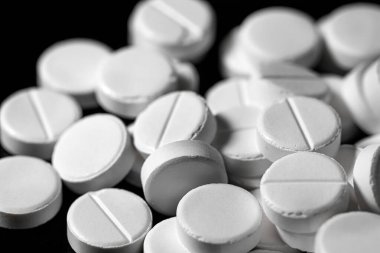 Makro, siyah arka planda beyaz ağrı kesici tableti kapat.