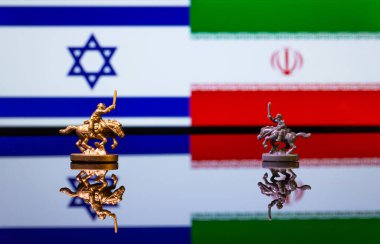 İsrail ve İran arasındaki savaşın kavramsal görüntüsü oyuncak askerler ve yansıtıcı bir arka plan üzerinde ulusal bayraklar kullanılıyor