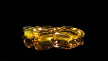 Omega 3 jel kapsülünü yansıtıcı siyah arka planda kapat