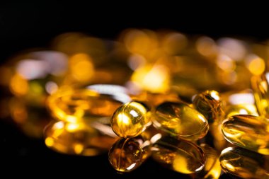 Omega 3 jel kapsülünü yansıtıcı siyah arka planda kapat