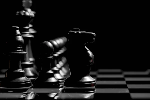 Detailní Záběr Šachových Figurek Zrcadlovém Povrchu Desky Hladkým Černým Pozadím — Stock fotografie