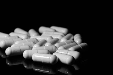 Makro, siyah arka planda beyaz ağrı kesici kapsülünü kapat.