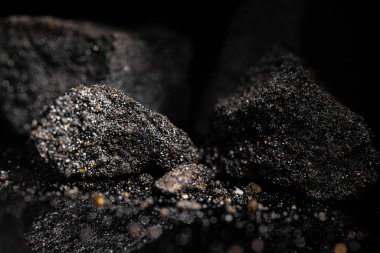 Macro, siyah yansıtıcı arka planda izole edilmiş hammadde platin ve krom kaplama kaya görüntüsünü kapat