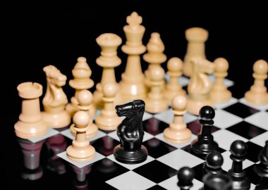 Yansıtıcı ayna yüzeyindeki siyah arkaplanı olan satranç taşlarını kapat