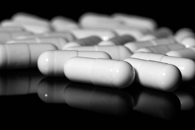 Makro, siyah arka planda beyaz ağrı kesici kapsülünü kapat.