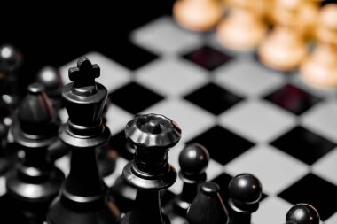 Yansıtıcı ayna yüzeyindeki siyah arkaplanı olan satranç taşlarını kapat