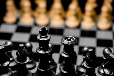 Yansıtıcı ayna yüzeyindeki siyah arkaplanı olan satranç taşlarını kapat