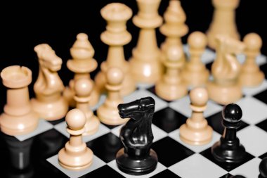 Yansıtıcı ayna yüzeyindeki siyah arkaplanı olan satranç taşlarını kapat