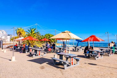 Cape Town, Güney Afrika - 12 Mayıs 2022: Sea Point sahilindeki açık kafe bankları