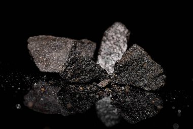 Macro, siyah yansıtıcı arka planda izole edilmiş hammadde platin ve krom kaplama kaya görüntüsünü kapat
