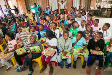 Johannesburg, Güney Afrika - 15 Aralık 2016: Genç Afrikalı okul çocukları Noel hediyelerini açıyor