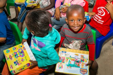 Johannesburg, Güney Afrika - 15 Aralık 2016: Genç Afrikalı okul çocukları Noel hediyelerini açıyor