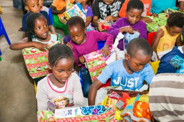Johannesburg, Güney Afrika - 15 Aralık 2016: Genç Afrikalı okul çocukları Noel hediyelerini açıyor