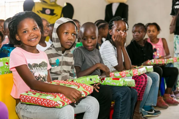 Johannesburg, Güney Afrika - 15 Aralık 2016: Genç Afrikalı okul çocukları Noel hediyelerini açıyor