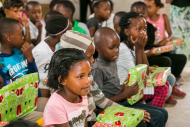 Johannesburg, Güney Afrika - 15 Aralık 2016: Genç Afrikalı okul çocukları Noel hediyelerini açıyor