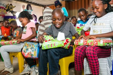 Johannesburg, Güney Afrika - 15 Aralık 2016: Genç Afrikalı okul çocukları Noel hediyelerini açıyor