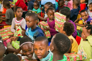 Johannesburg, Güney Afrika - 15 Aralık 2016: Genç Afrikalı okul çocukları Noel hediyelerini açıyor