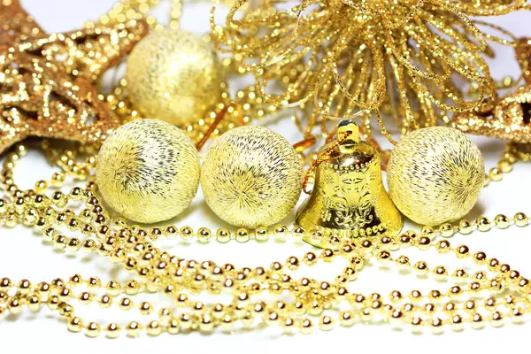 Bolas e sino no fundo de coisas douradas de Natal — Fotografia de Stock
