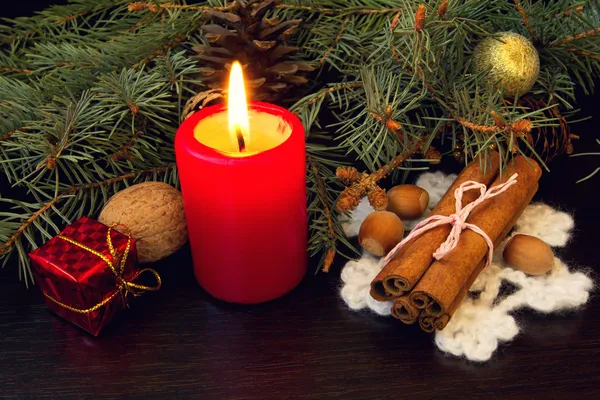 Burning red candle and cinnamon sticks — Stock Photo, Image