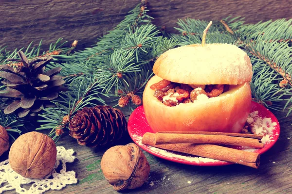 Печёное яблоко на Рождество, коричные палочки, орехи — стоковое фото