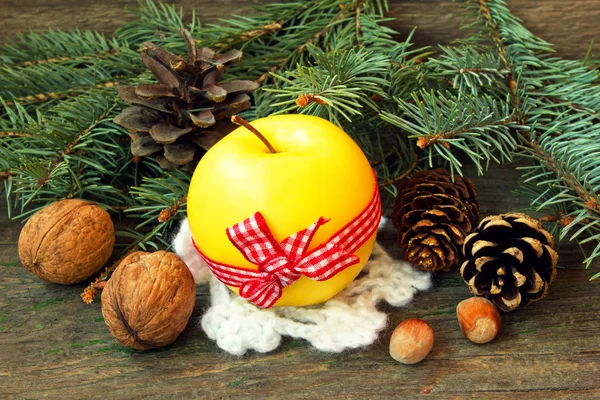 Manzana amarilla y nueces sobre fondo de madera. snack de Navidad — Foto de Stock